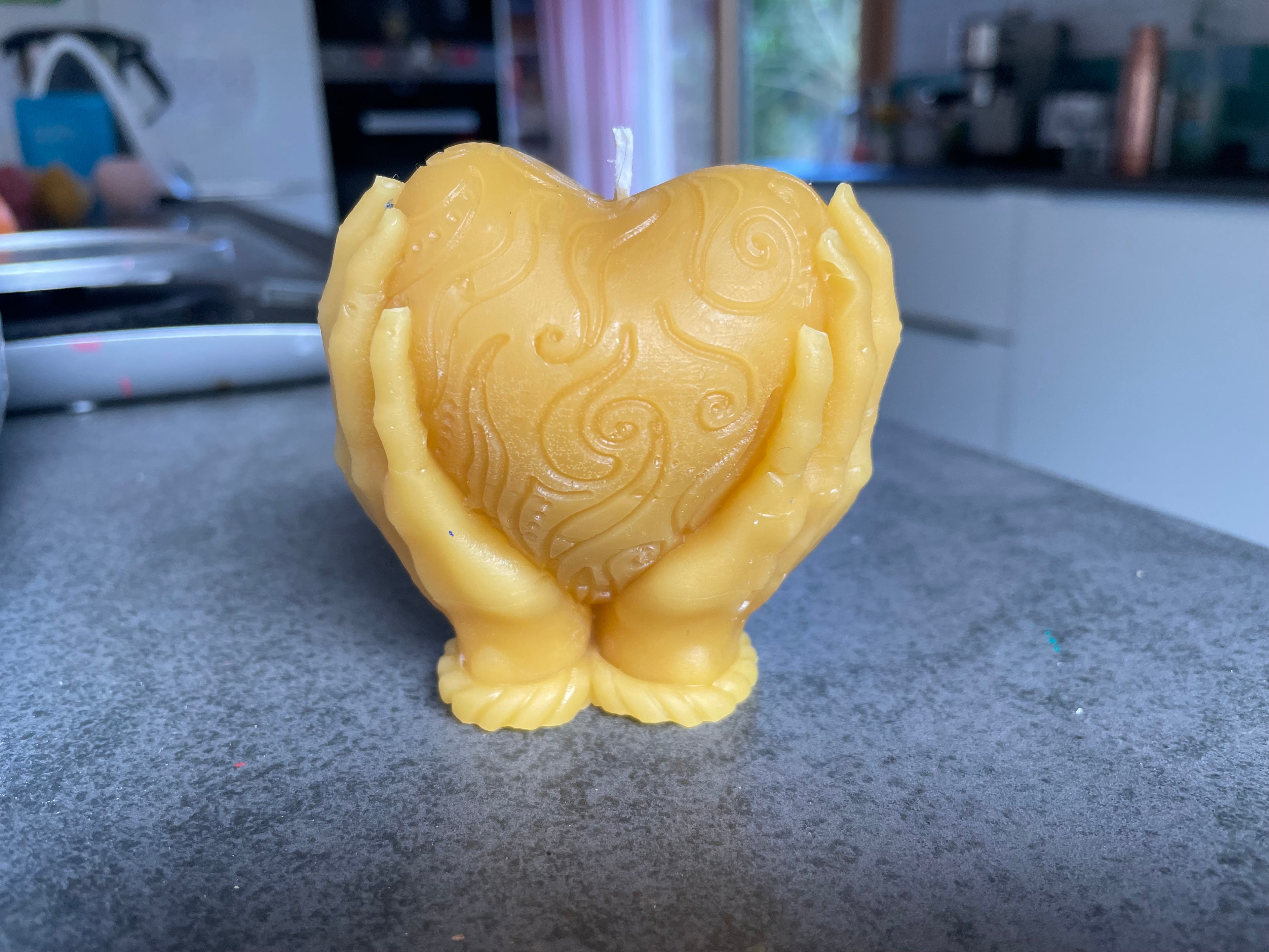 Bienenwachskerze mit Hand und Herz