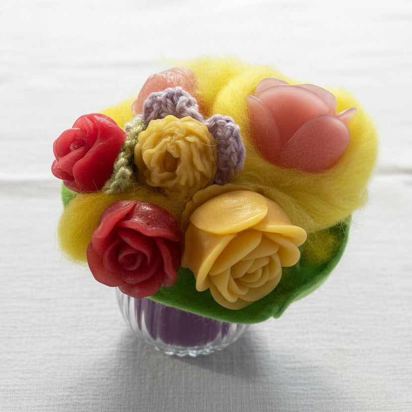 Handgemachter Blumenstrauß aus Wachsblumen und gelber Schafwolle in Glasvase