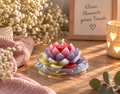 Bunte handgemachte Lotuskerze aus Kerzenresten auf Glasteller in gemütlicher Dekoration – Regenbogen Creations