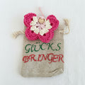 Handgehäkelter Schmetterling Glücksbringer in Rosa und Creme auf kleinem Stoffbeutel mit der Aufschrift „Glücksbringer“ – liebevoll handgemacht von Regenbogen Creations 💛