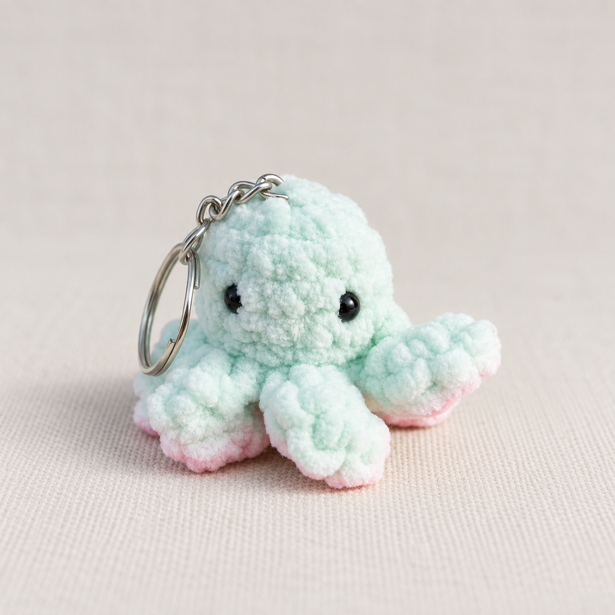 Handgehäkelter Oktopus-Schlüsselanhänger in Mint mit rosa Tentakelspitzen – handgemachtes Unikat von Regenbogen Creations.“