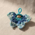 Handgehäkelter Schmetterling anhänger in Blau mit Holzperlenkopf – kleines Glücksbringer Geschenk
