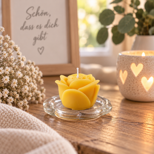 Handgegossene gelbe Rosenkerze auf Glasschale in gemütlichem Wohnambiente