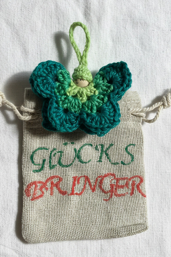 Handgemachter gehäkelter Schmetterling als Glücksbringer im Säckchen mit Aufschrift Glücksbringer – liebevolle Geschenkidee