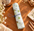Handgemachtes Rollmäppchen mit Vogel- und Blumenmuster aus Baumwolle, zusammengerollt auf Holztisch.