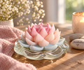 Handgegossene Lotuskerze in Rosa und Hellblau auf Glasteller in gemütlicher Wohnatmosphäre – Regenbogen Creations