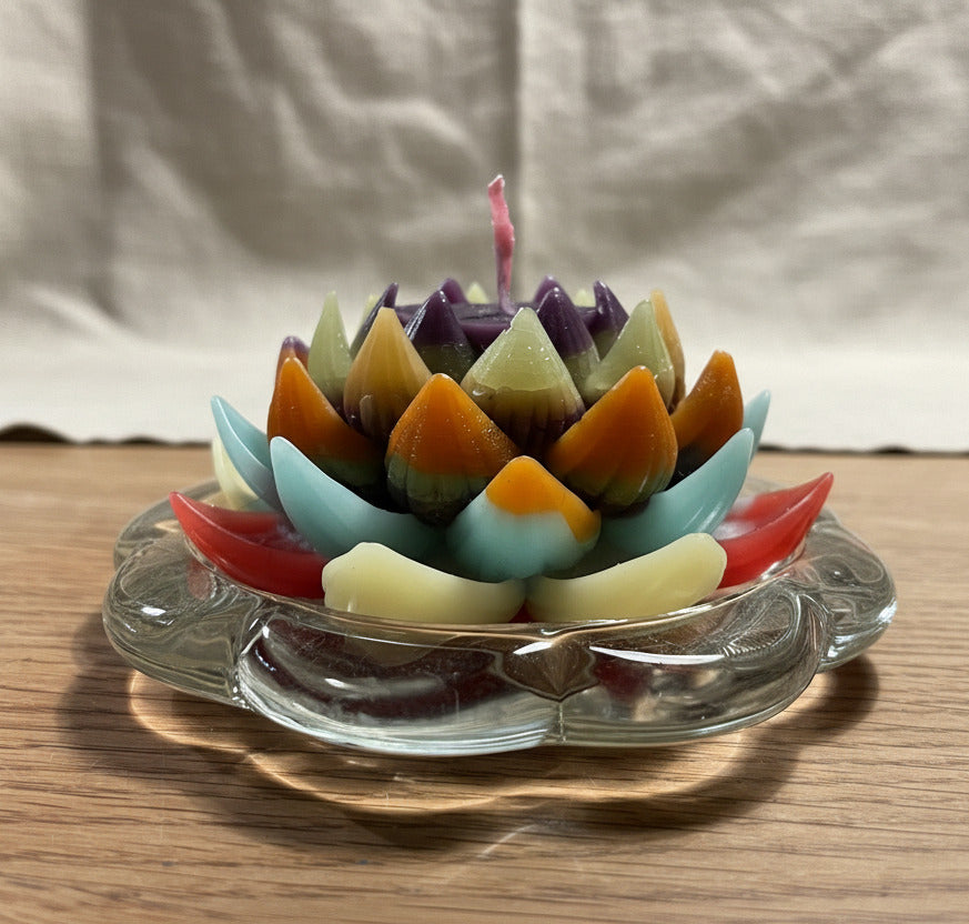 Mehrfarbige Lotusblüten Kerze auf Glasuntersetzer als dekorative Upcycling Kerze
