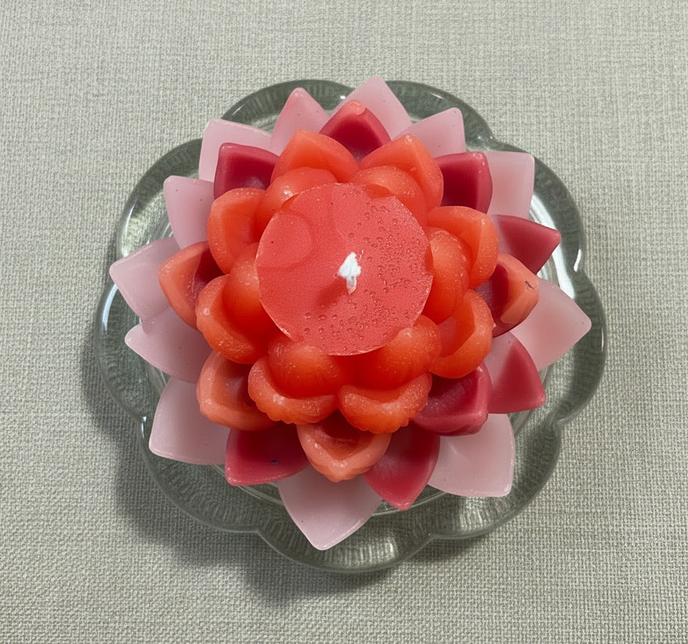 Lotusblüten Kerze in Rosa und Orange auf Glasuntersetzer – dekorative Lotuskerze von oben
