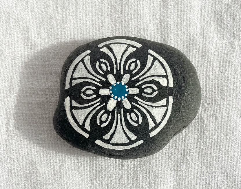 Handbemalter schwarzer Mandala Stein mit weißem Muster und blauem Zentrum im minimalistischen Stil