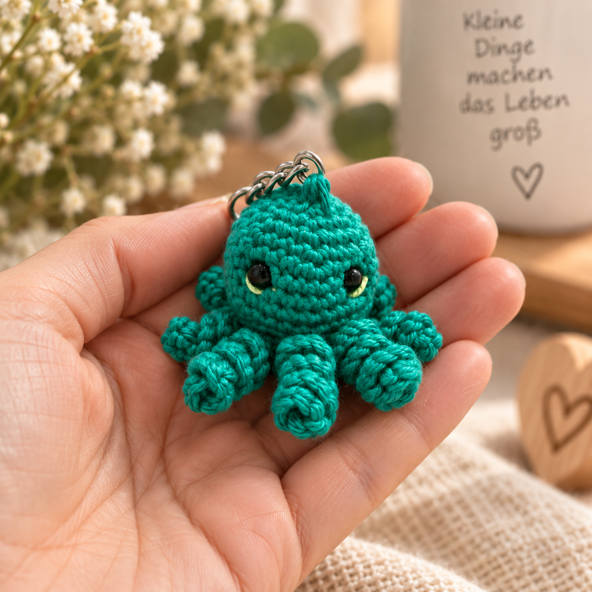 Kleiner grüner gehäkelter Oktopus-Schlüsselanhänger in einer Hand – liebevoll handgemacht