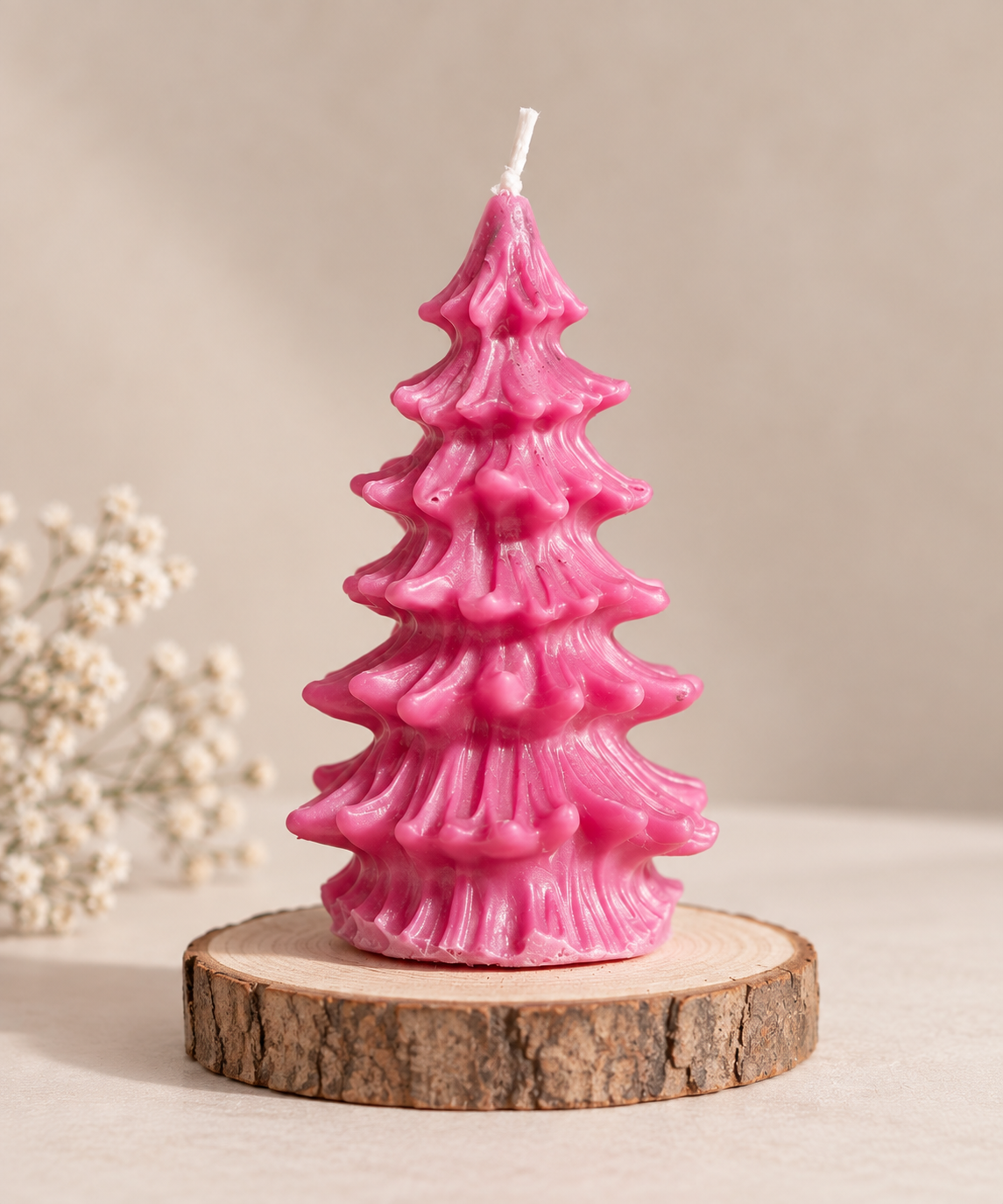  Handgemachte pinke Weihnachtsbaum-Kerze auf einer natürlichen Holzscheibe.