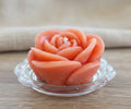Handgegossene Rosenkerze in Orange auf Glasuntersetzer – dekorative handgemachte Kerze