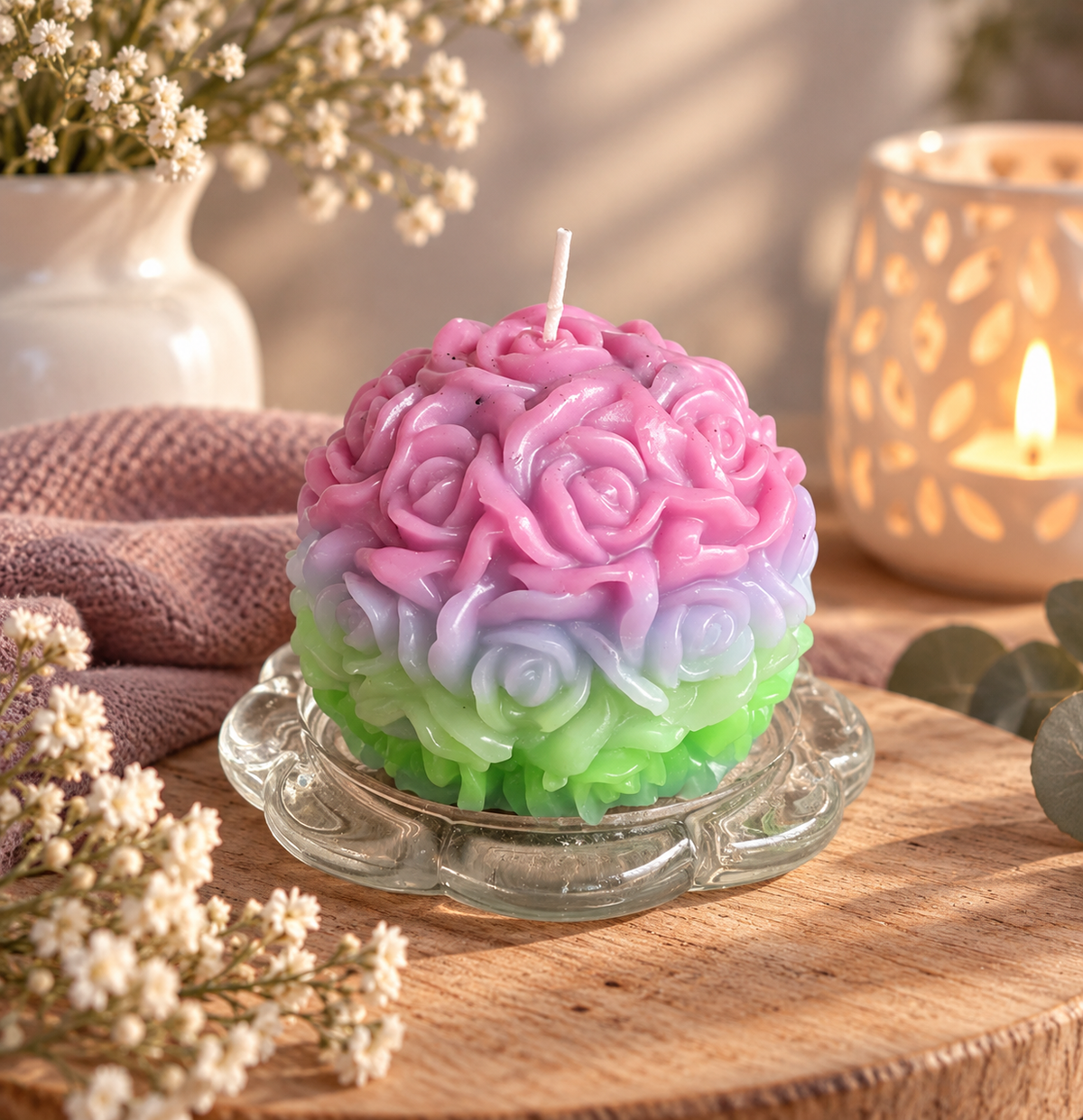 Handgegossene Rosenkerze in Rosa, Lila und Grün aus Upcycling-Wachs in stimmungsvoller Dekoration