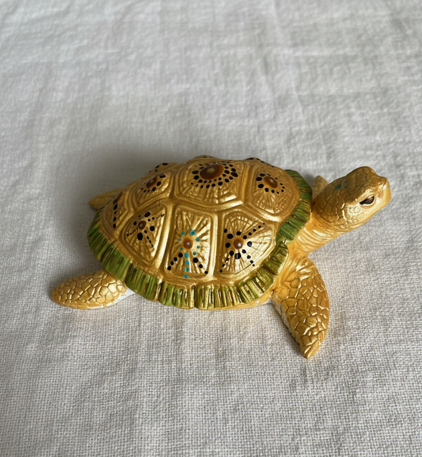 Handbemalte goldene Schildkrötenfigur mit feinem Dot-Painting-Muster in Schwarz, Grün und Türkis auf hellem Hintergrund 💛
