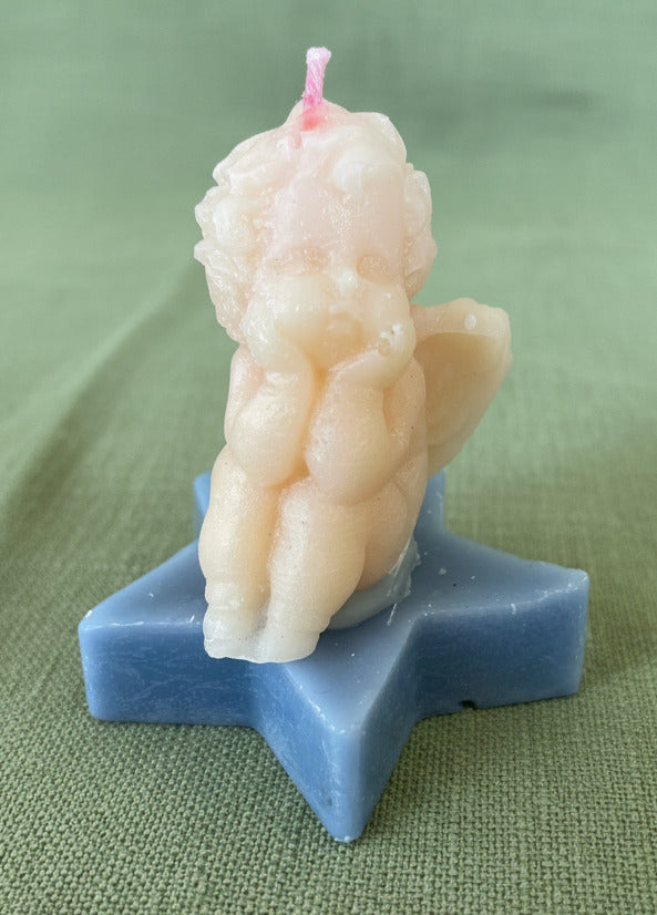 Handgemachte Schutzengel Kerze aus Kerzenresten auf blauem Stern, nachhaltige Geschenkidee