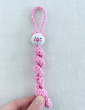 Handgemachtes rosa Sorgenbärchen aus Häkelarbeit mit süßem Bärchengesicht auf Holzuntergrund 🧸💗