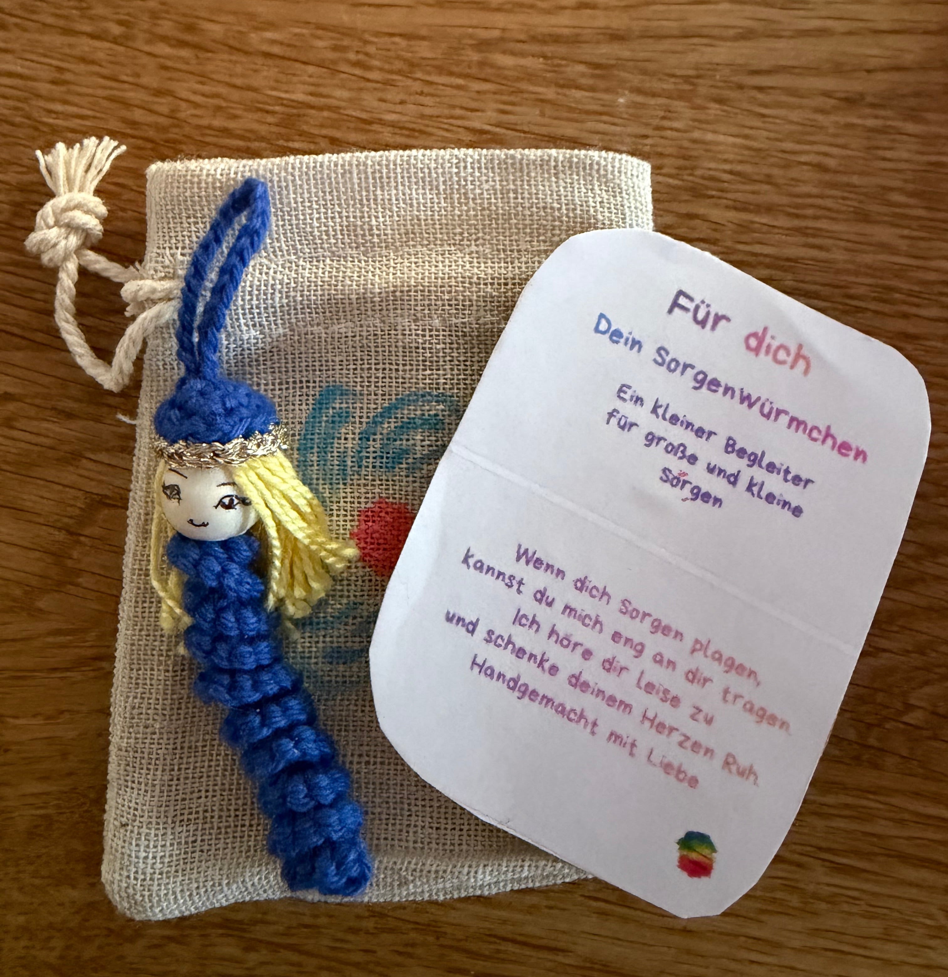 Handgehäkeltes Sorgenmädel mit Karte und Stoffbeutel als Mutmacher, Trostgeschenk und Glücksbringer für Kinder.