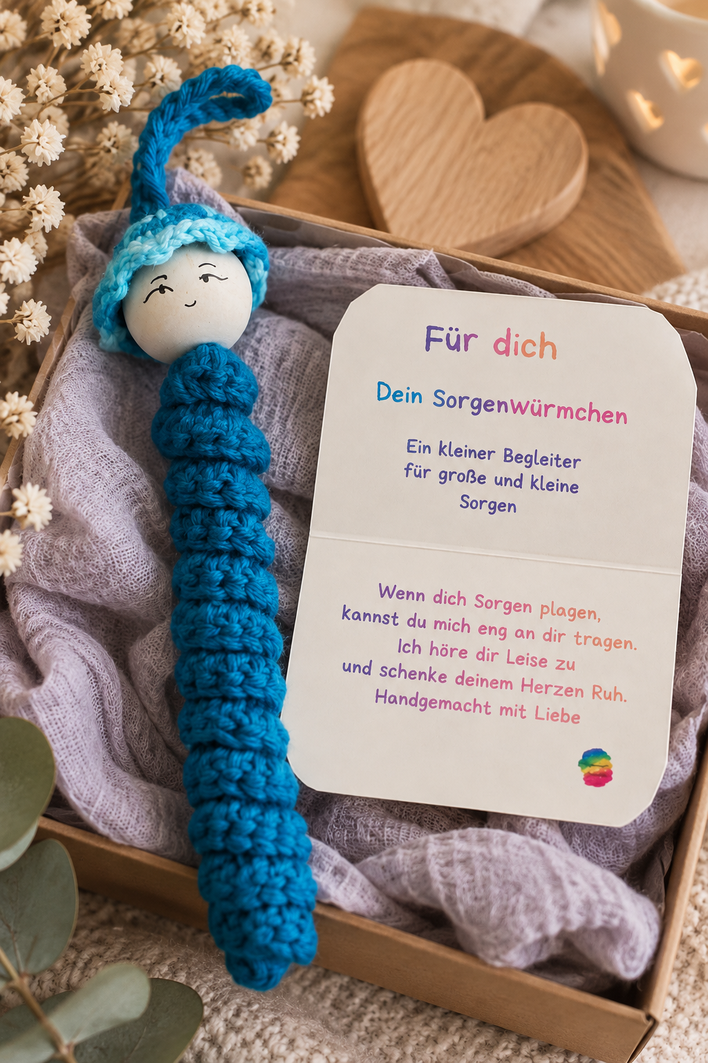 Handgemachtes Sorgenwürmchen in Türkis mit Kärtchen liebevoll in einer Geschenkbox arrangiert.
