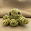 Grüner gehäkelter Tintenfisch Schlüsselanhänger im Amigurumi Stil, handgemacht mit liebevollen Details
