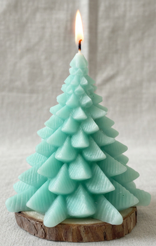 Grüne Weihnachtsbaum Kerze aus Kerzenresten handgemacht nachhaltig auf Holzscheibe brennend