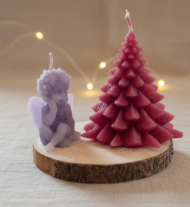 Handgegossene Weihnachtsbaumkerze in Rot neben kleinem Engel auf Holzscheibe – dekorative Weihnachtskerze